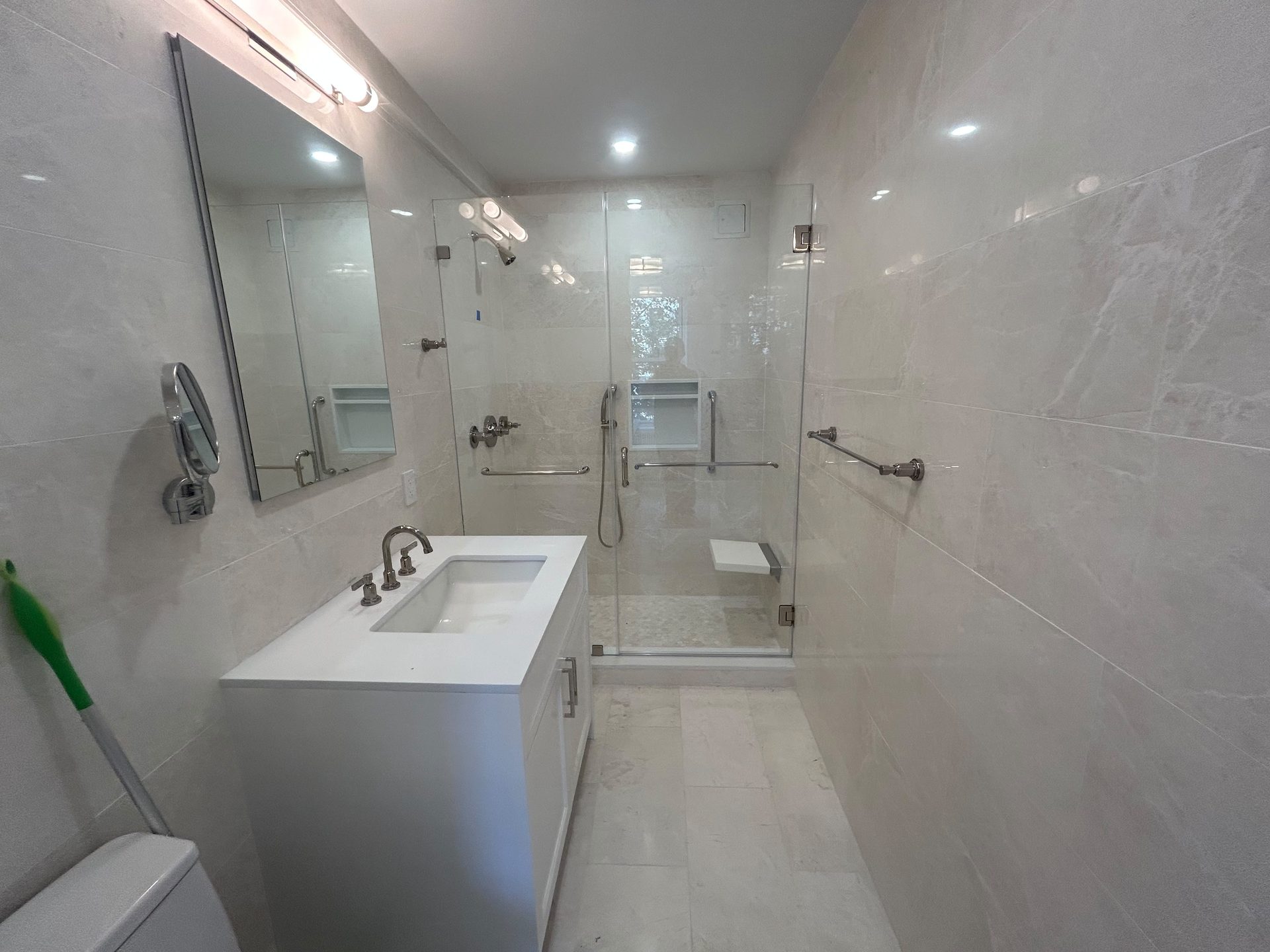 Full marble bathroom with a frameless glass walk-in shower