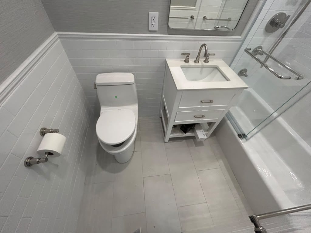 Finished bathroom with a custom white vanity and glass shower
