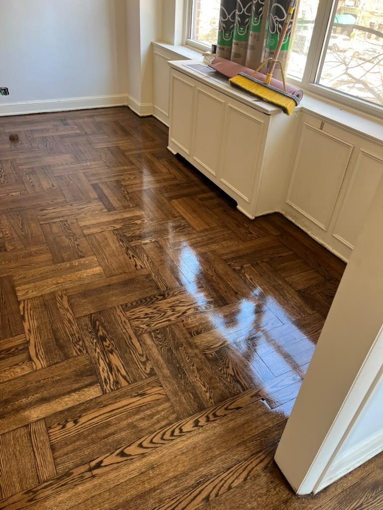 High-gloss parquet floor with a restored radiator enclosure