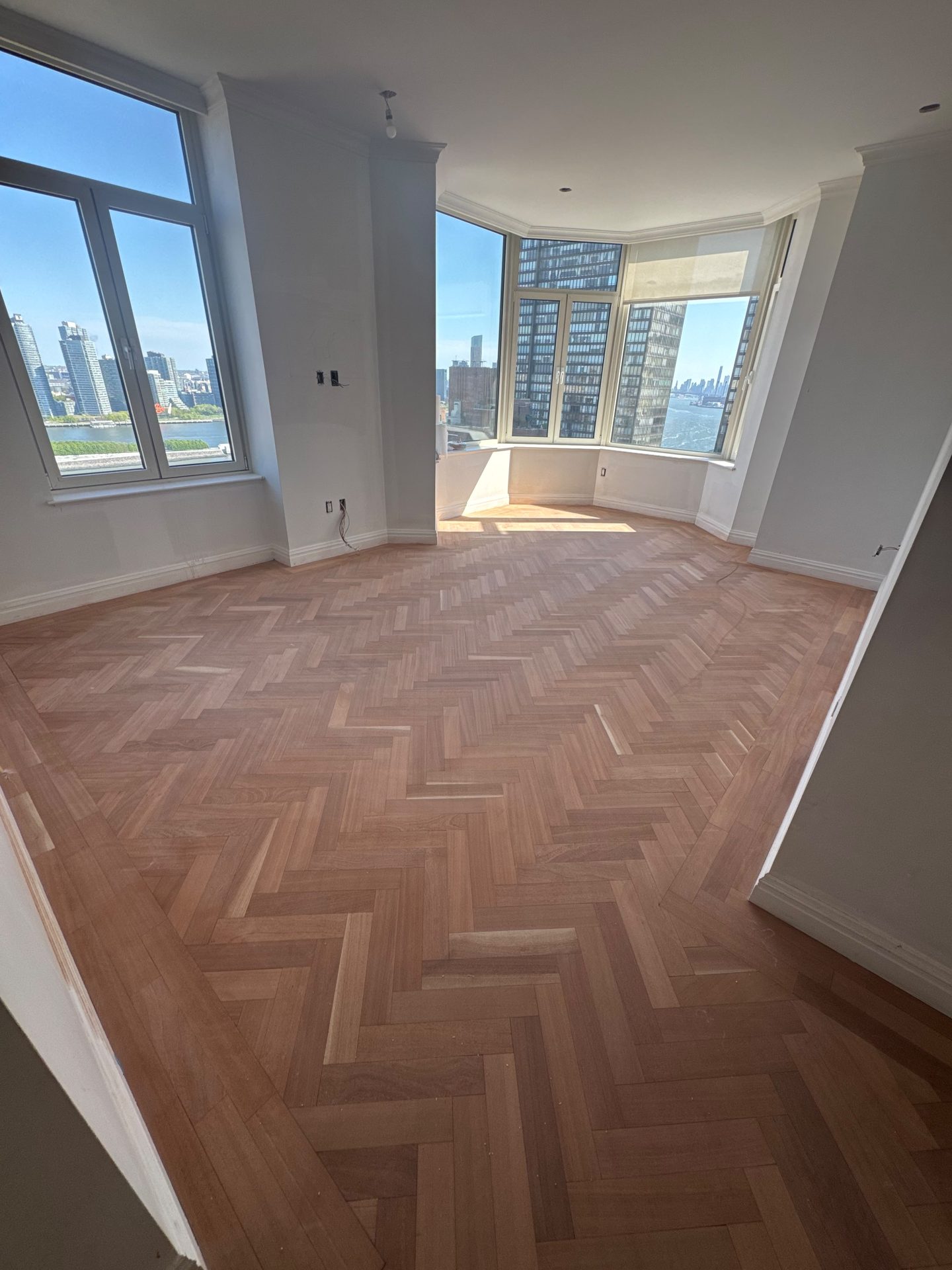 Wide herringbone flooring filled with natural light and a city view