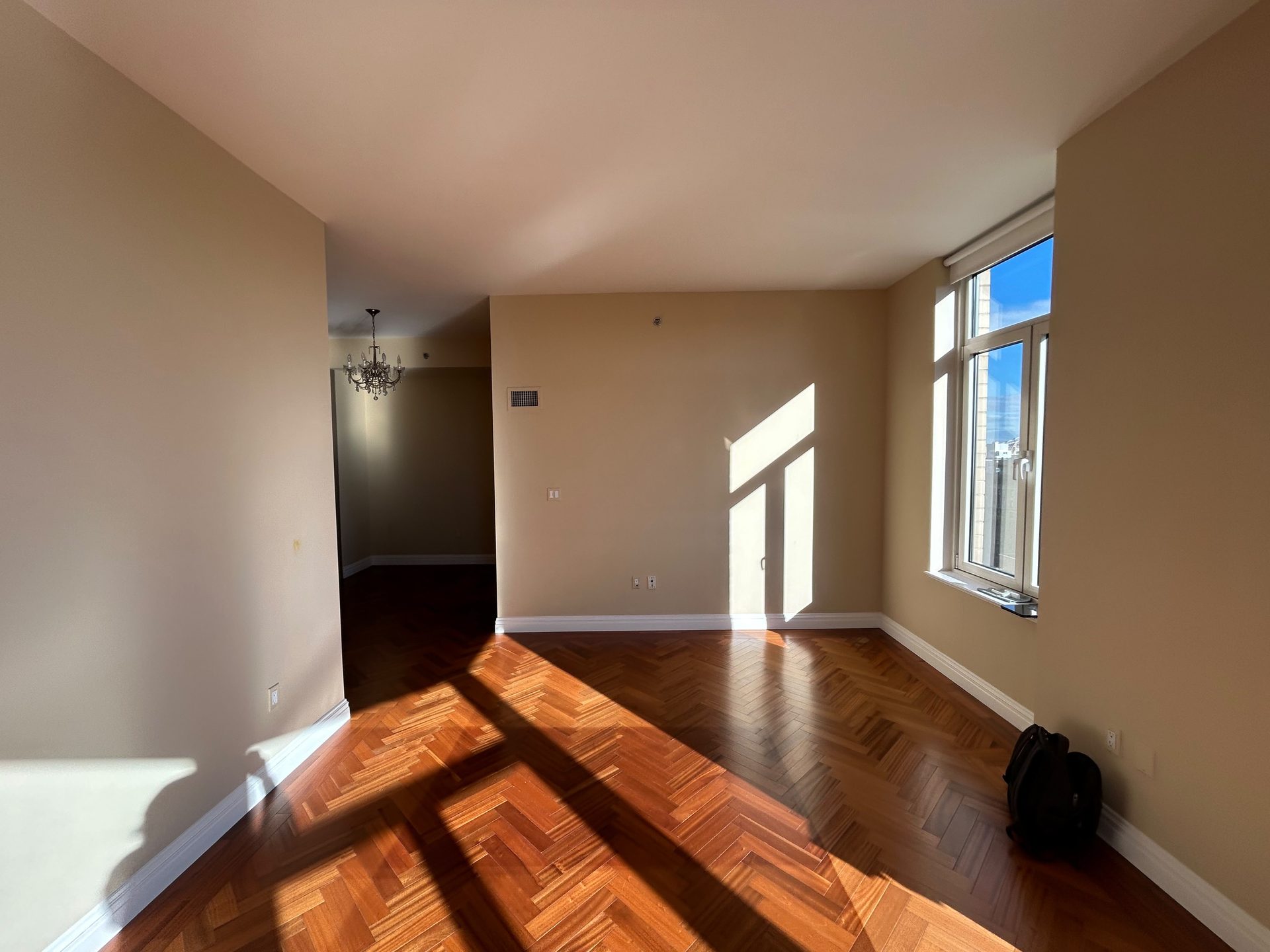 A sunlit hallway of herringbone hardwood