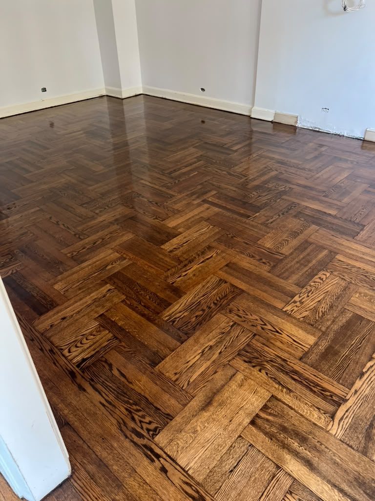 Mirror-finish herringbone floor reflecting the window light