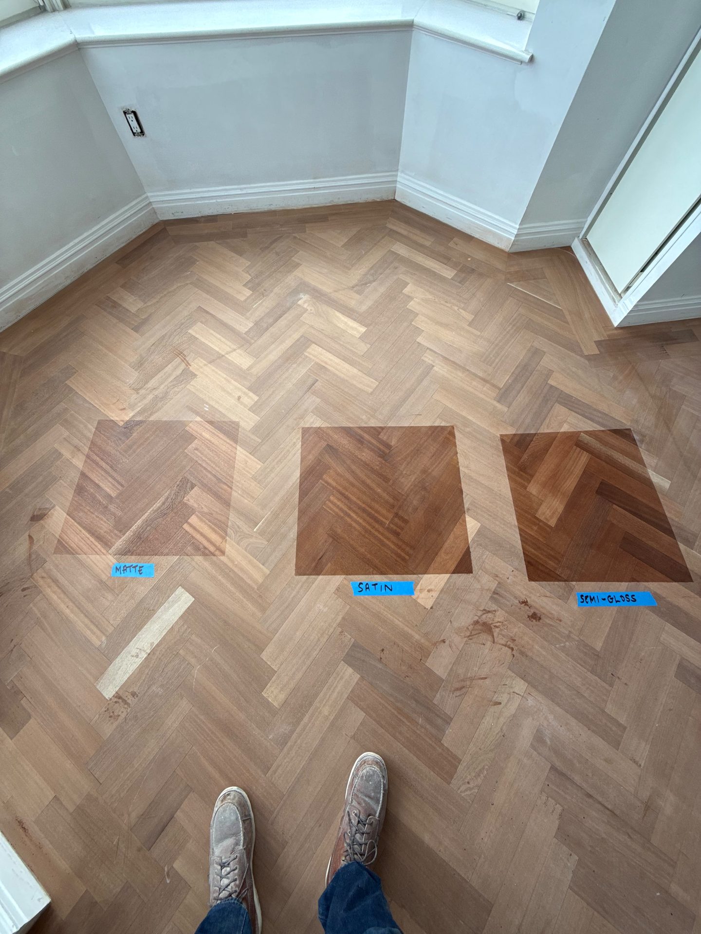 Herringbone floor installation in progress with stain samples