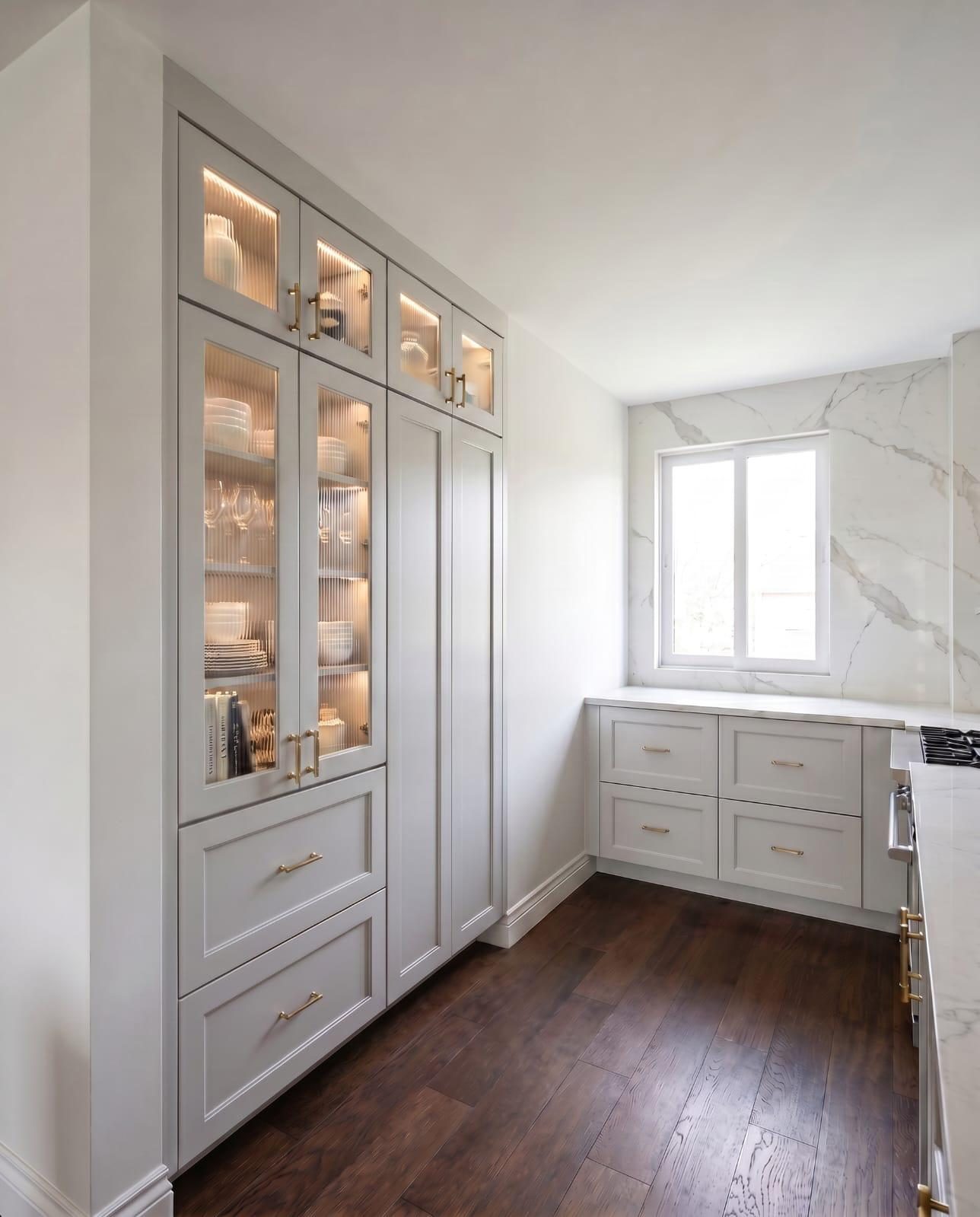 Custom kitchen cabinetry with illuminated glass display fronts