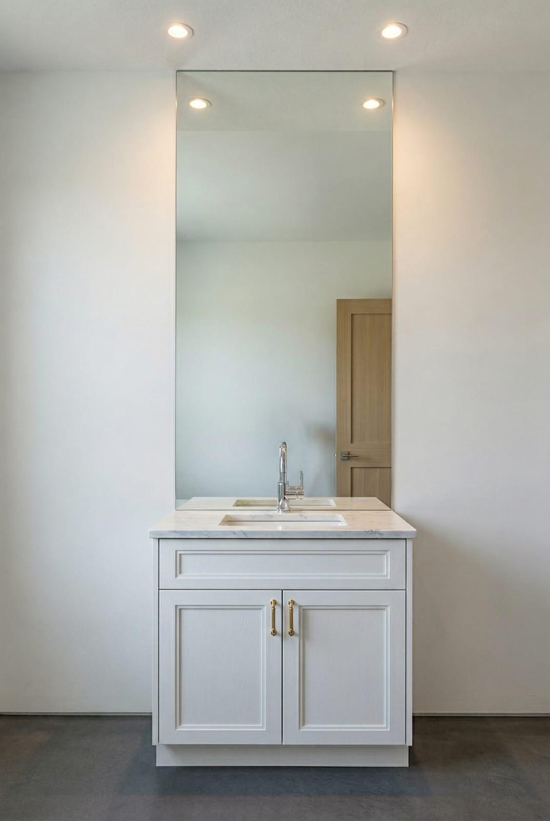 A minimalist custom vanity with brass hardware